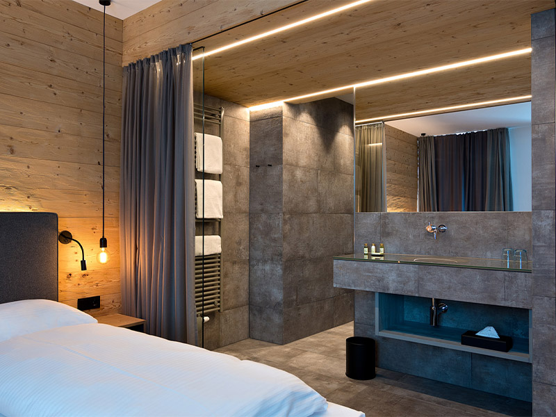 Hotelzimmer mit Bett und offenem Badezimmer mit Beleuchtung